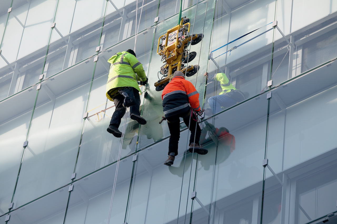 Professionals cleaning exterior windows on commercial building