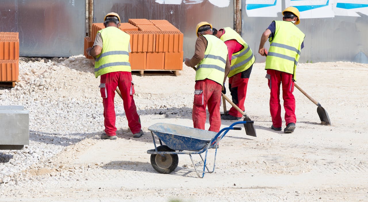 four man cleaning up construction debris