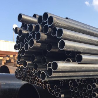 cargamento de diferentes tipos de tuberías de acero en camiones siendo transportadas en México